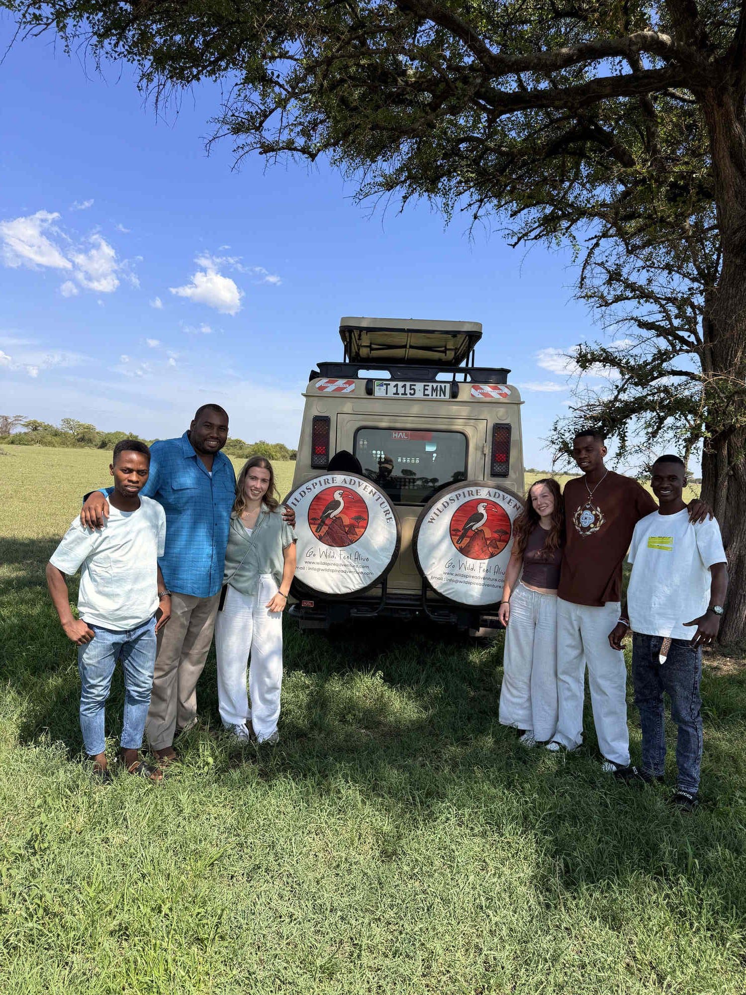 Wildspire founders beside a custom safari Land Cruiser on the Serengeti plains